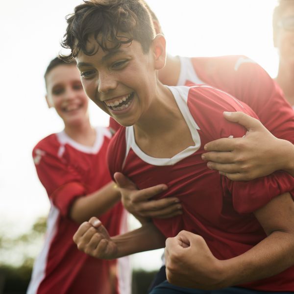 A boy celebrating his victory in the game and friend hugging him
